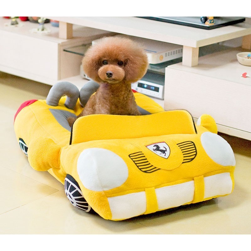 Golden puppy sitting in yellow car-shaped pet nest — soft plush dog and cat bed